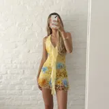 Vestido corto amarillo con estampado floral y animal print, escote en V con volados en cascada al frente, tirantes finos y diseño ajustado.