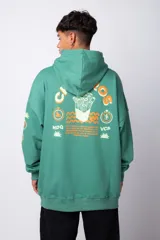Buzo canguro oversize de algodón rústico, color gris claro, con capucha y cordones ajustables con logo estampado. Presenta un diseño gráfico pequeño en el pecho y detalles estampados en la manga.