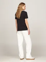 Remera negra de algodón con cuello redondo y logo de Tommy Hilfiger estampado en blanco en el pecho.