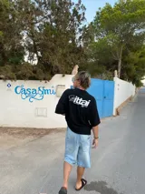 Remera celeste con estampado blanco en la espalda que dice "Ibiza Island", "Ittai", "Designed in Ibiza" y "SS26 Ibiza Ags".