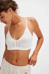 Bralette de encaje negro con copas triangulares, escote festoneado, tirantes finos regulables y banda inferior elastizada.