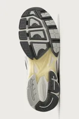 Zapatilla deportiva tipo running color marrón, con parte superior confeccionada en combinación de piezas de malla, gamuza y material sintético. Posee suela con volumen y diseño irregular.