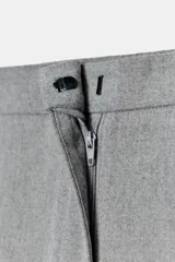 Pantalón recto color marrón oscuro, de tiro medio, con cintura elástica en la espalda, bolsillos delanteros de vivo y cierre frontal con cremallera, botón interior y gancho.