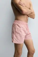 Bañador de hombre color azul marino, confeccionado en tejido técnico, con cintura elástica ajustable mediante cordón. Presenta bolsillos laterales y un bolsillo trasero de plastrón. Incluye forro interior.
