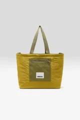 Bolso tote reversible color verde militar confeccionado en lona, con doble asa superior y logo estampado vertical en el frente.