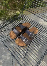Sandalias de dos tiras marrones de ecocuero estilo Birkenstock, con hebillas metálicas ajustables y plantilla anatómica.