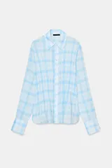 Camisa de manga larga con estampado de cuadros vichy en tonos celeste y blanco. Presenta cuello clásico, cierre frontal con botones y detalle de fruncido en la parte central delantera.