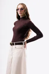 Polera de punto acanalado en color marrón chocolate, con cuello alto y mangas largas ajustadas.