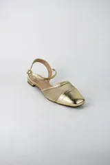 Sandalias planas color dorado, con puntera cerrada, diseño combinado con tela tipo red y tira ajustable al tobillo con hebilla.