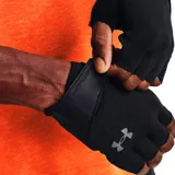 Guantes de entrenamiento Under Armour sin dedos, color negro, con cierre de velcro en la muñeca y el logo de la marca en tono gris.