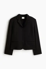 Blazer negro de punto pesado, con solapas de muesca, botonadura sencilla y corte entallado. Presenta hombreras, bolsillos delanteros ribeteados y abertura decorativa en los puños.