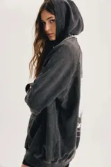 Buzo oversize negro con efecto acid wash, capucha, bolsillo canguro y mangas largas de corte raglán.