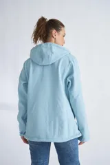 Campera de neopreno color rojo con capucha ajustable, cierre frontal completo y bolsillos laterales. Presenta puños ajustables con velcro y un parche circular decorativo en la manga izquierda.