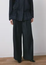 Pantalón vaquero de corte wide leg y tiro medio, confeccionado en tejido 100% algodón con diseño largo y lavado rinse wash. Cuenta con trabillas, detalle de pinzas, dos bolsillos laterales y cierre oculto de ganchos y cremallera.