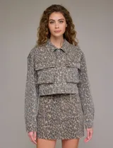 Campera de jean estampada con animal print de leopardo en tonos beige y gris, marca Hidden. Tiene cuello solapa, abertura frontal con botones metálicos, bolsillos delanteros y ruedo elastizado en la espalda.