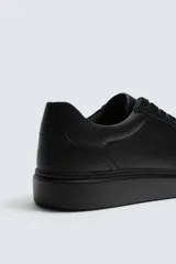 Zapatilla urbana monocolor de diseño minimalista con cordones al tono, puntera redondeada y suela con volumen.
