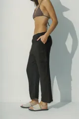 Pantalón de lino blanco, de corte recto y tiro alto, con bolsillos laterales y traseros.