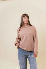 Sweater tejido de punto color blanco, con cuello alto y diseño en relieve tipo chevron en la parte frontal. Presenta un calce holgado con terminaciones acanaladas en puños y ruedo.
