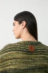 Sweater de tejido de punto con diseño oversize, cuello en V y mangas largas. Presenta un patrón de rayas horizontales en tonos verdes y marrones.