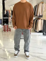 Buzo oversize marrón de manga larga, confeccionado en tela texturada con líneas verticales, cuello redondo y calce holgado.