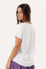 Remera blanca de manga corta con estampa frontal de cerezas y la frase 'Not your baby' en letras doradas. Confeccionada en tejido suave con caída, presenta un corte con espalda ligeramente más larga.