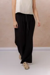 Pantalón amarillo de corte amplio y pierna recta, confeccionado en tela liviana con caída fluida. Cuenta con cintura elastizada, cordón regulable en contraste y bolsillos laterales.