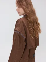 Campera de denim a rayas verticales con cuello de pana en color bordó. Presenta cierre frontal, mangas desmontables con cierre en los hombros, canesú en el pecho y bolsillos de parche cuadrados.