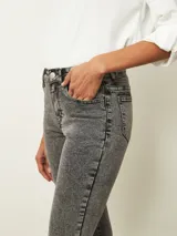 Jean de corte oxford en color negro, con tiro medio y ajuste en la cintura y caderas, ensanchándose desde la rodilla hacia el ruedo.