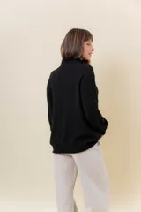 Polera de tejido de punto con textura marcada, cuello alto y diseño oversize con hombros caídos y terminaciones acanaladas.