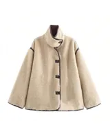 Chaqueta tipo teddy de corte holgado, color beige, con cuello alto, cierre frontal con botones y detalles de ribetes en color marrón oscuro.