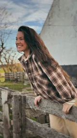 Camisa de algodón con patrón a cuadros tartán en tonos marrones y beige, de corte relajado, con cuello camisero, bolsillos frontales y cierre de botones.