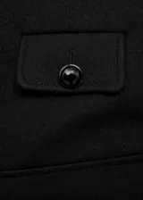 Chaqueta recta color negro con cuello mao, cierre frontal y bolsillos delanteros con solapa y botones joya.