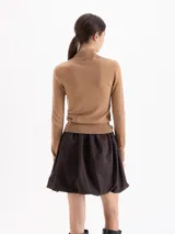 Polera de tejido fino con cuello alto, manga larga y calce entallado al cuerpo.
