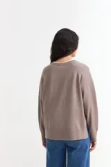 Sweater de tejido de punto color azul marino, con cuello abierto tipo polo y tajos laterales en el ruedo. Presenta mangas largas con puños acanalados y un corte holgado.