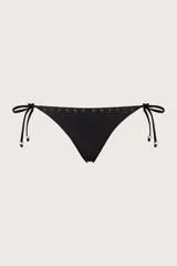 Calzón de bikini de tiro bajo color negro, con laterales de lazos ajustables con cuentas decorativas y una hilera de pequeños aros metálicos dorados en el borde superior.