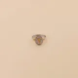 Anillo de diseño artesanal fabricado en plata 925 y oro 18k, con un motivo central circular que representa el símbolo de la medicina. Presenta una combinación de metales en tonos plata y oro, con una banda delgada y elegante.