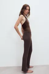 Pantalón de felpa gris melange, tiro alto con cintura elástica ancha y corte flare en las piernas.