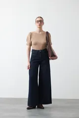 Remera negra de manga corta con textura floral en relieve. Presenta un diseño de inspiración romántica con mangas ligeramente abullonadas que aportan estructura y un ajuste al cuerpo.