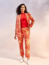 Blazer color crema de manga larga, con solapas amplias y cinturón para ajustar a la cintura.