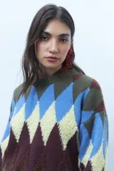 Sweater de punto grueso con diseño de rombos en tonos azul, marrón, rosa y gris.