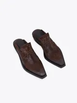 Zueco estilo western de cuero vacuno plateado, con costuras decorativas en la capellada, punta cuadrada y taco bajo de 4 cm.