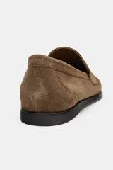 Mocasín plano de mujer confeccionado en serraje, con diseño de antifaz en el empeine, costuras visibles y punta redonda.