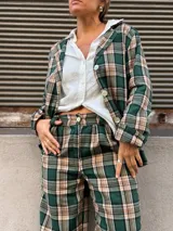 Pantalón de corte recto y tiro alto con estampado de cuadros en tonos verdes, beige y negro.