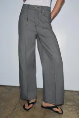 Jeans wide leg de tiro alto y diseño relaxed fit, confeccionados en denim azul marino con patrón de rayas verticales blancas. Cuenta con cinco bolsillos, cierre frontal con cremallera y botón, y detalle de nervio delantero con pespuntes a contraste.
