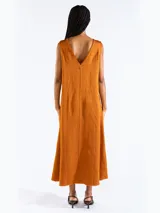 Vestido largo sin mangas de corte recto y holgado, con escote bote y bolsillos laterales. Confeccionado en mezcla de lyocell, viscosa y lino.