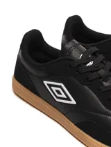 Championes Umbro modelo Track, color negro, con suela de goma color caramelo. Presenta el logo Umbro en el lateral en color blanco.