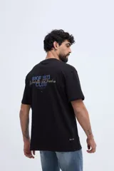 Remera oversize negra de manga corta, con calce amplio y estampa gráfica en la espalda con texto en tonos azules y dorados.