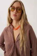 Camisa de lino color marrón, de manga larga y calce holgado, con cuello mao y escote en V.