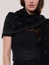 Pashmina rectangular negra confeccionada en tejido liviano y vaporoso con sutil transparencia y caída fluida, adornada con pequeños apliques de strass.
