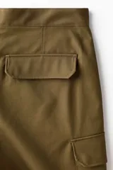 Pantalón cargo de algodón en color verde militar con corte relajado, bolsillos al bies en los laterales, bolsillos de parche con solapa en las piernas y cierre frontal con botón a presión.